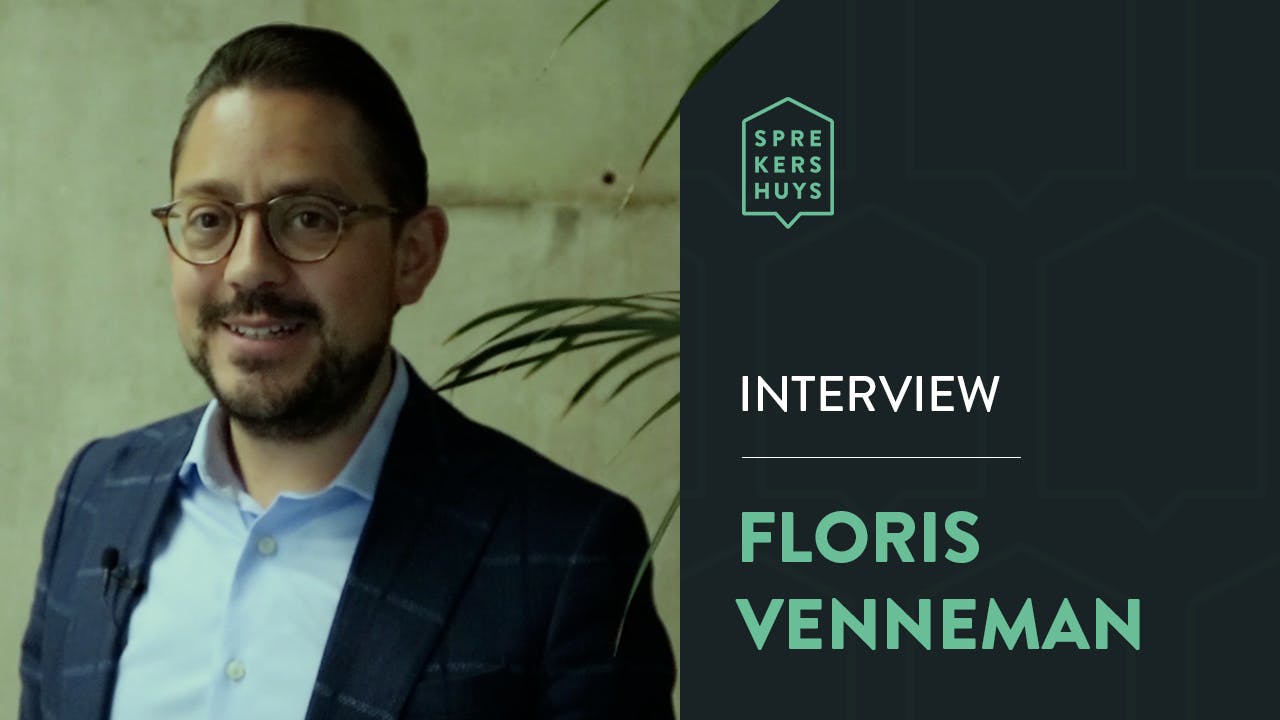 Floris Venneman glimlachend in blauw pak met de tekst 'Floris Venneman Interview'