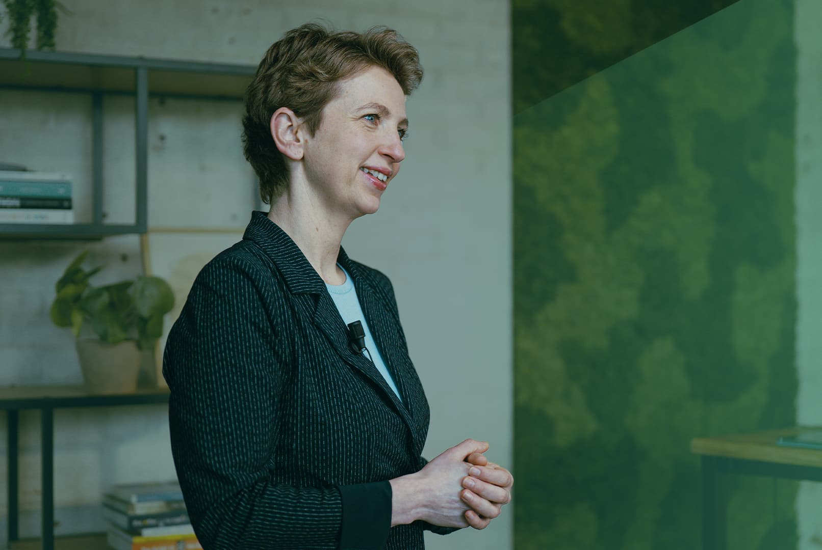 Marijke Roskam glimlachend kijkend naar zijkant met groene gloed over zich heen