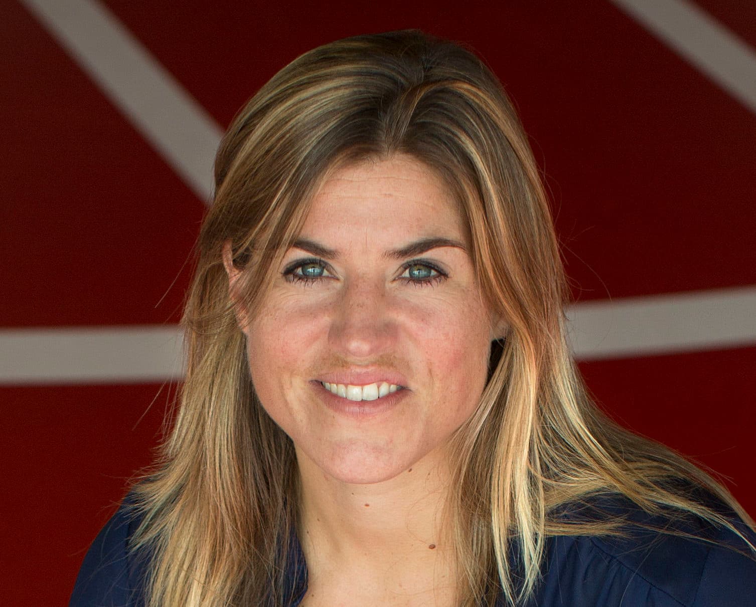 Kim Lammers lachend bij rood met witte achtergrond