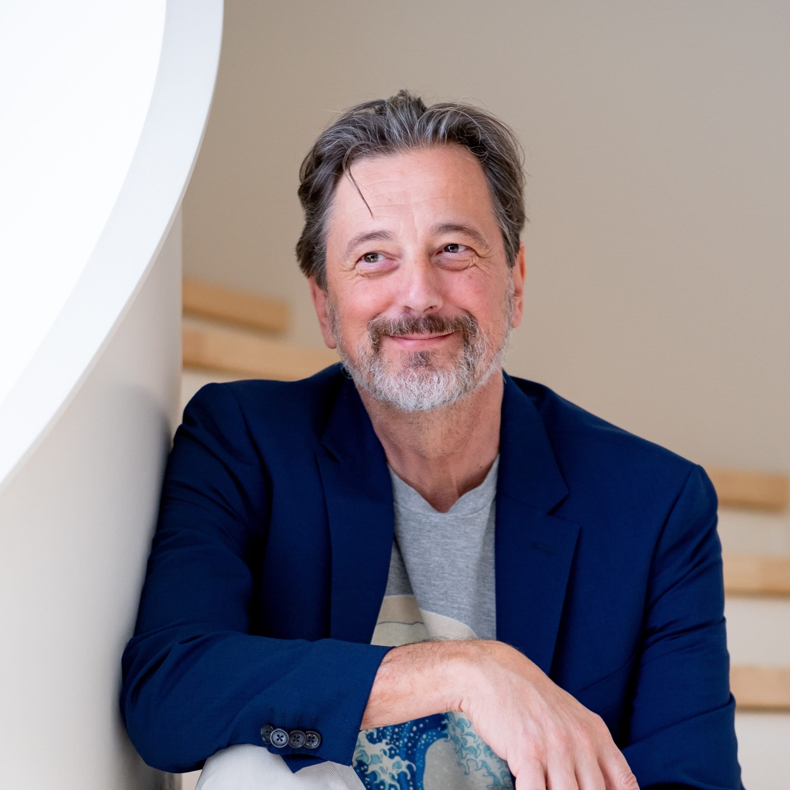 Rik Vera op trap glimlachend en opzij kijkend