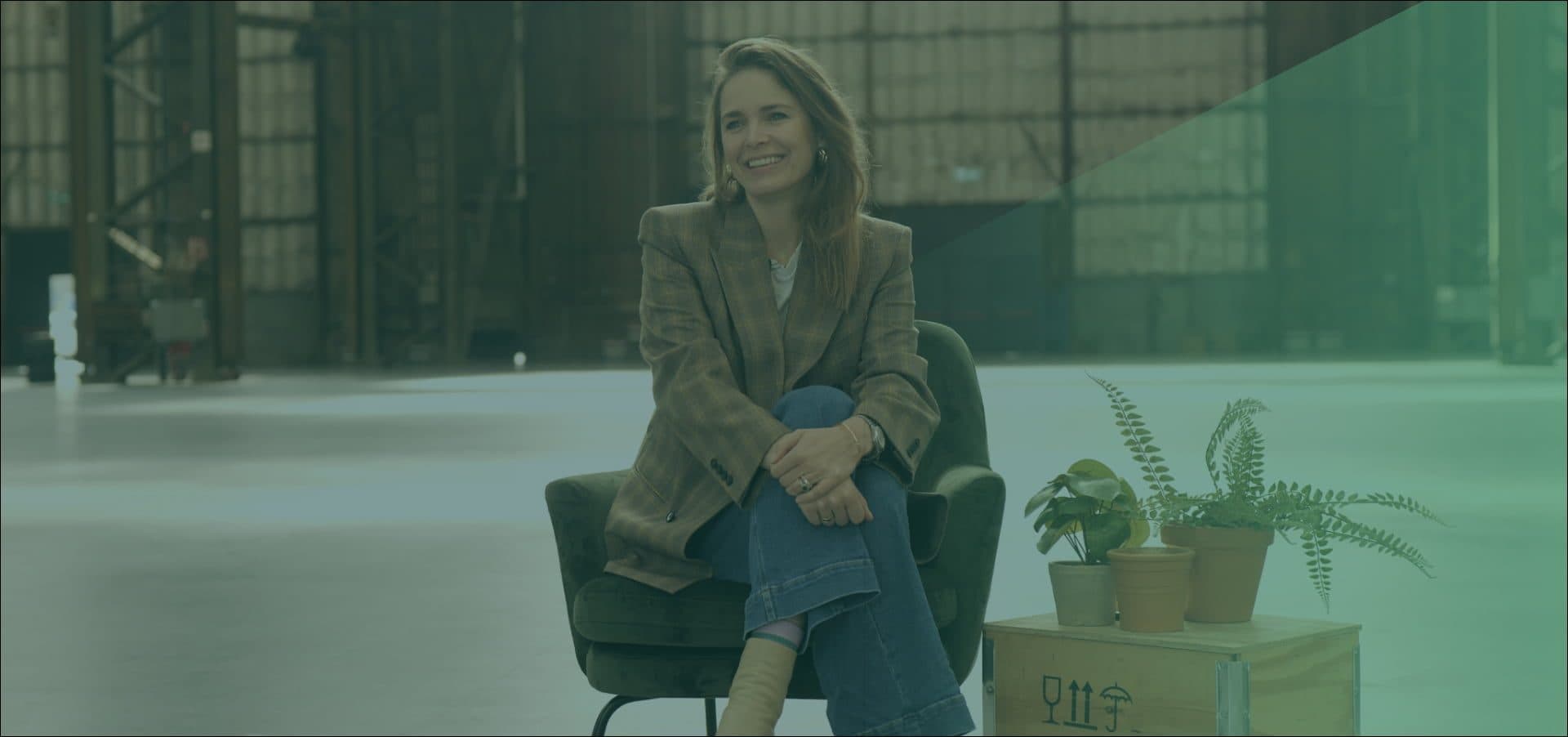 Hanna Verboom glimlachend zittend op een stoel kijkend naar de zijkant met groene gloed over zich