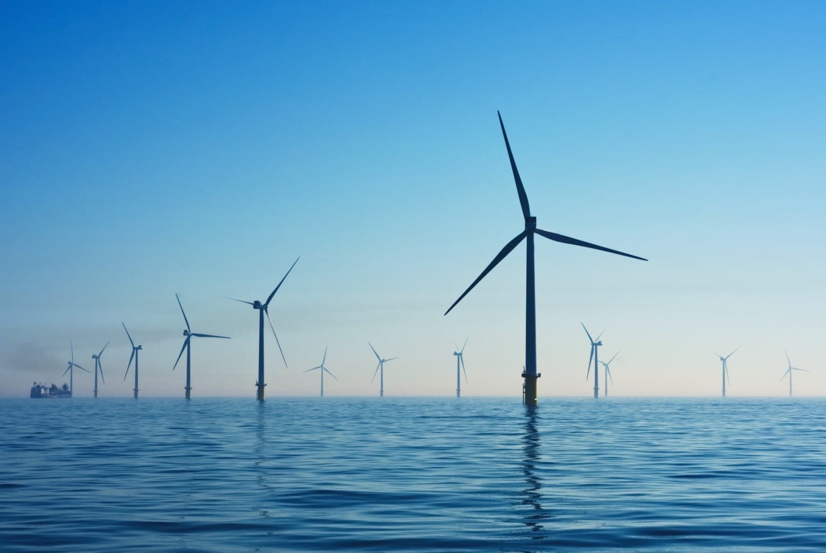 Windmolens op water met blauwe lucht