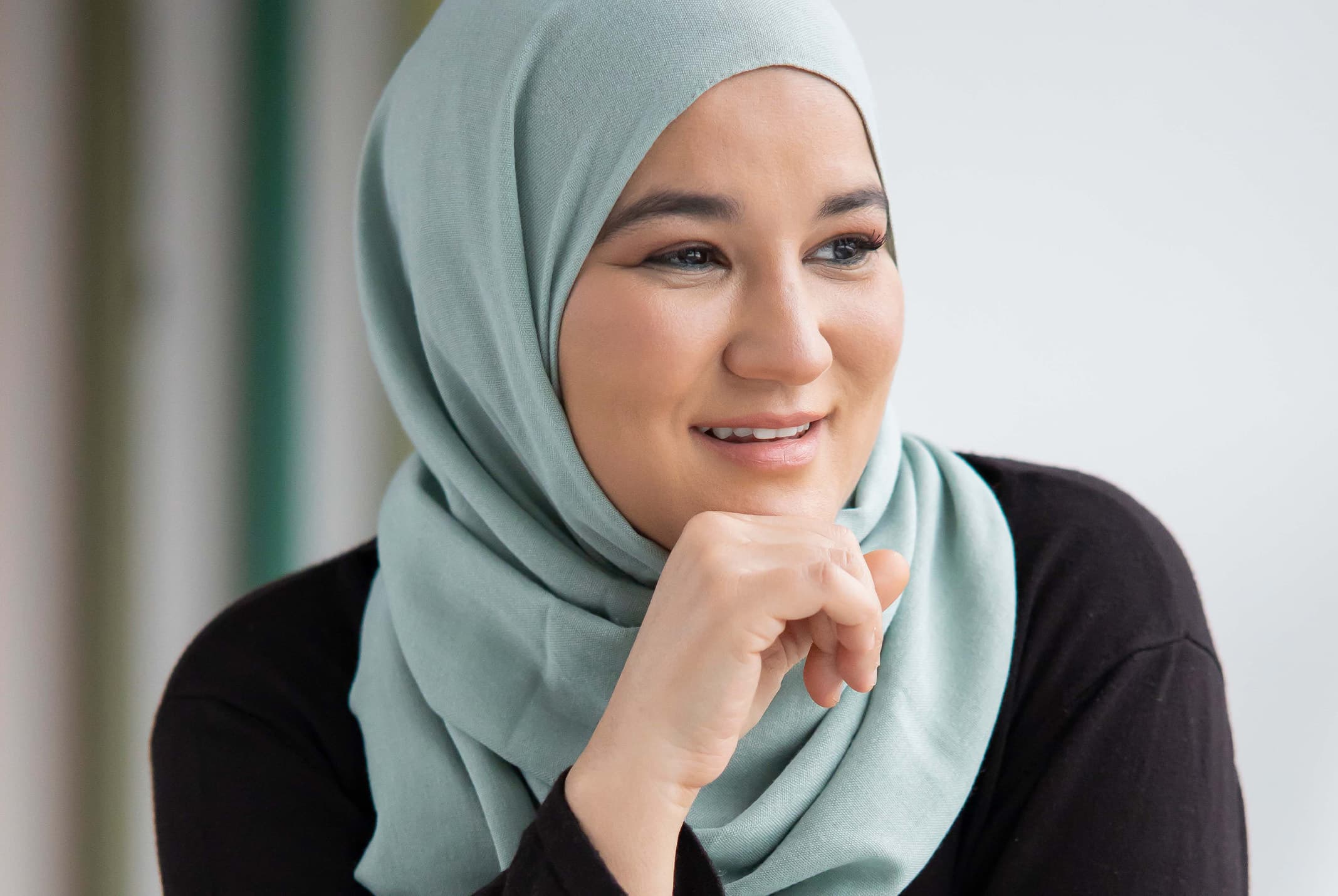 Houda Loukili lachend met hand bij kin