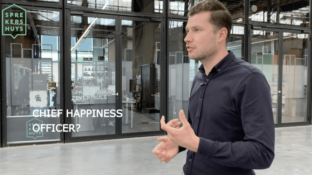 Arjen Banach aan het praten met de tekst 'Chief happiness officer' in beeld