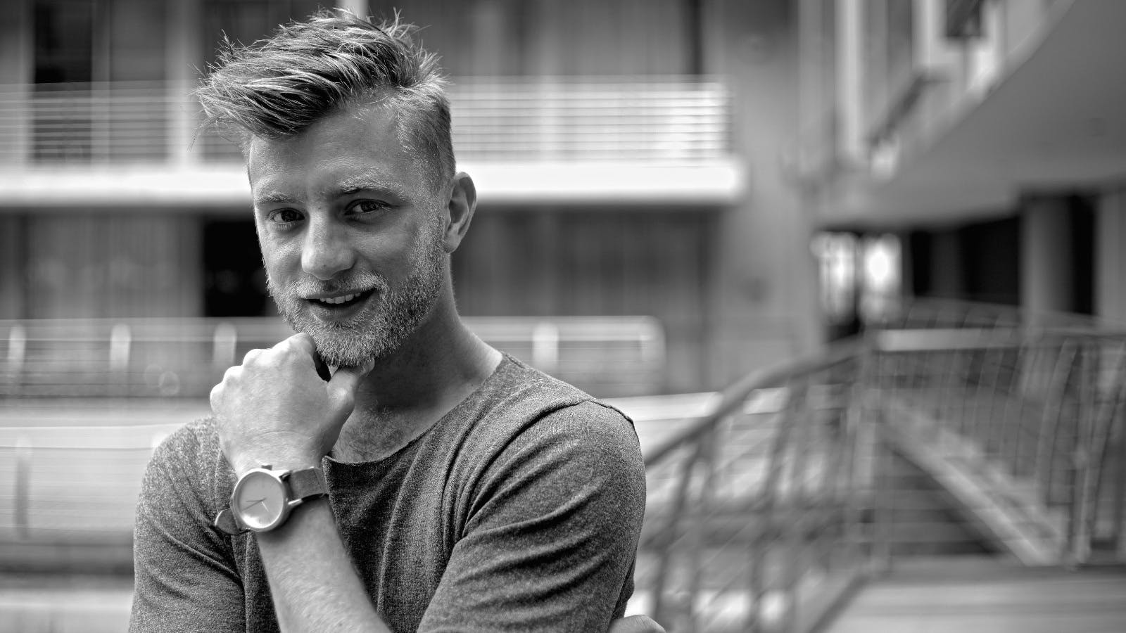 Jan Versteegh zwart wit foto buiten poserend voor camera met hand bij gezicht