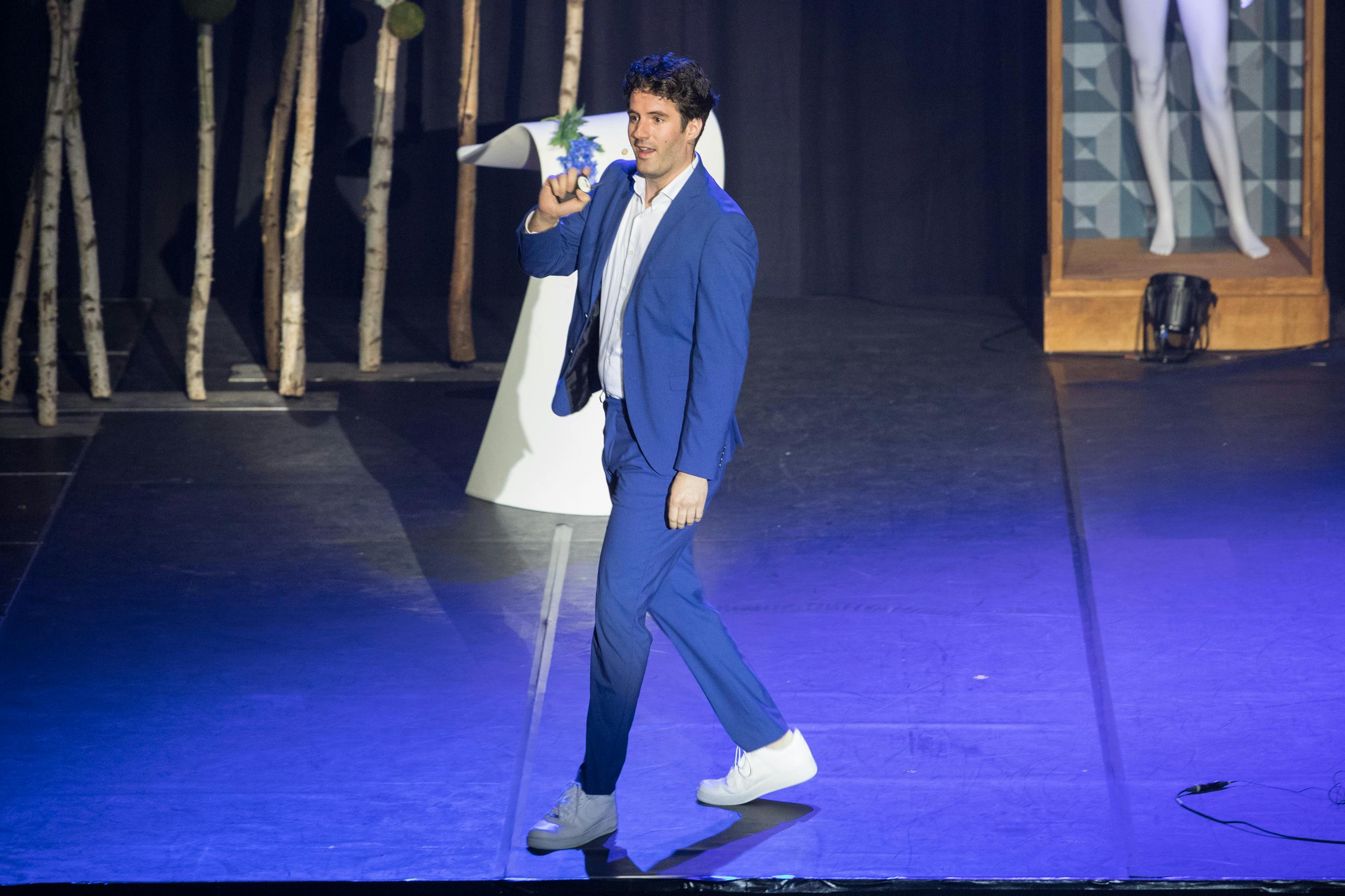 Sydney Brouwer presenteert lopend in blauw pak