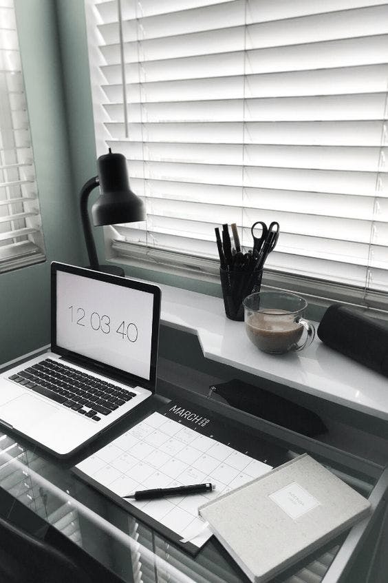 Wit bureau met laptop planner en lamp