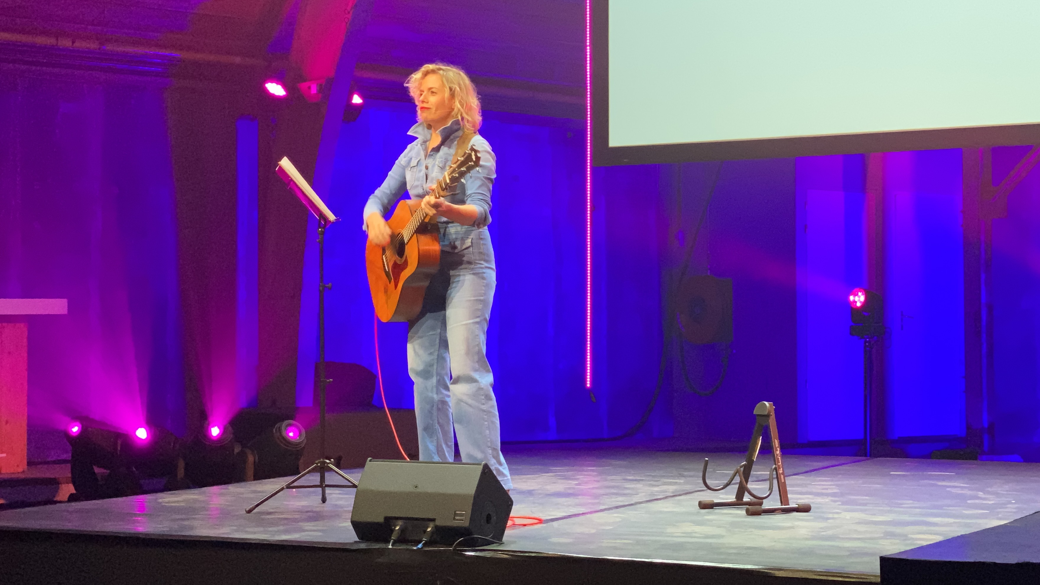 Vrouw op een podium met een gitaar