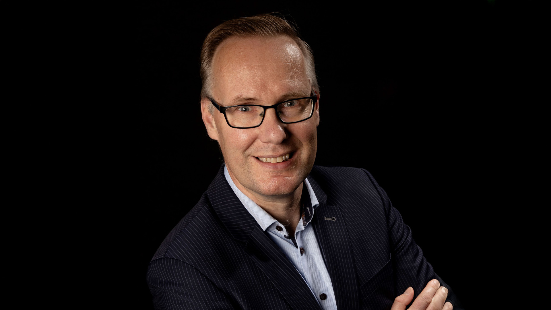 Man met pak aan op een zwart achtergrond