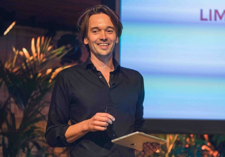 Spreker Joel aan 't Goor op het podium met tablet