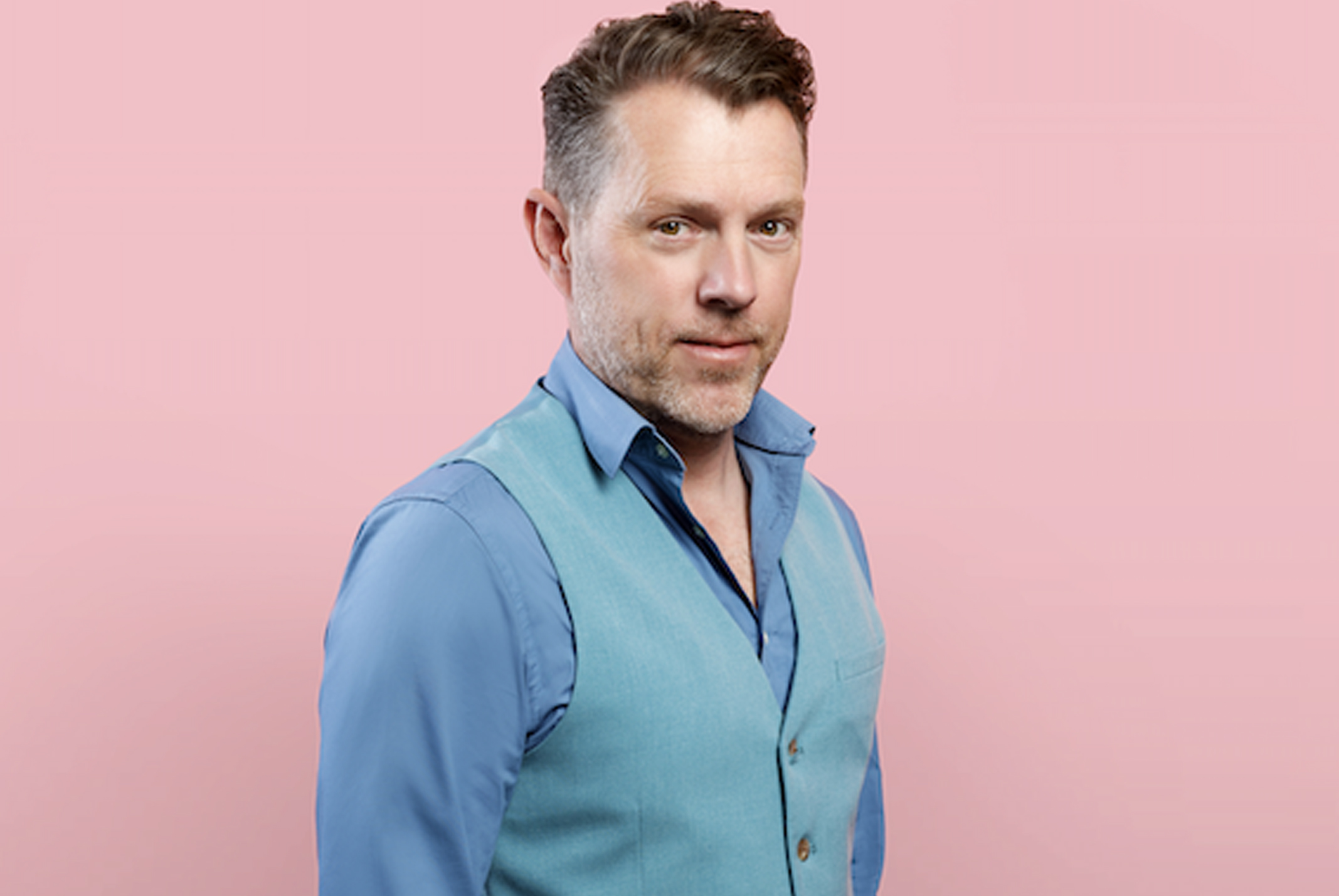 Max van den Burg roze achtergrond blauw pak