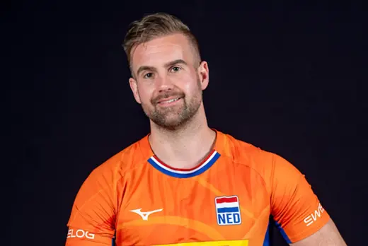 Robin van Damme in oranje shirt voor zwarte achtergrond
