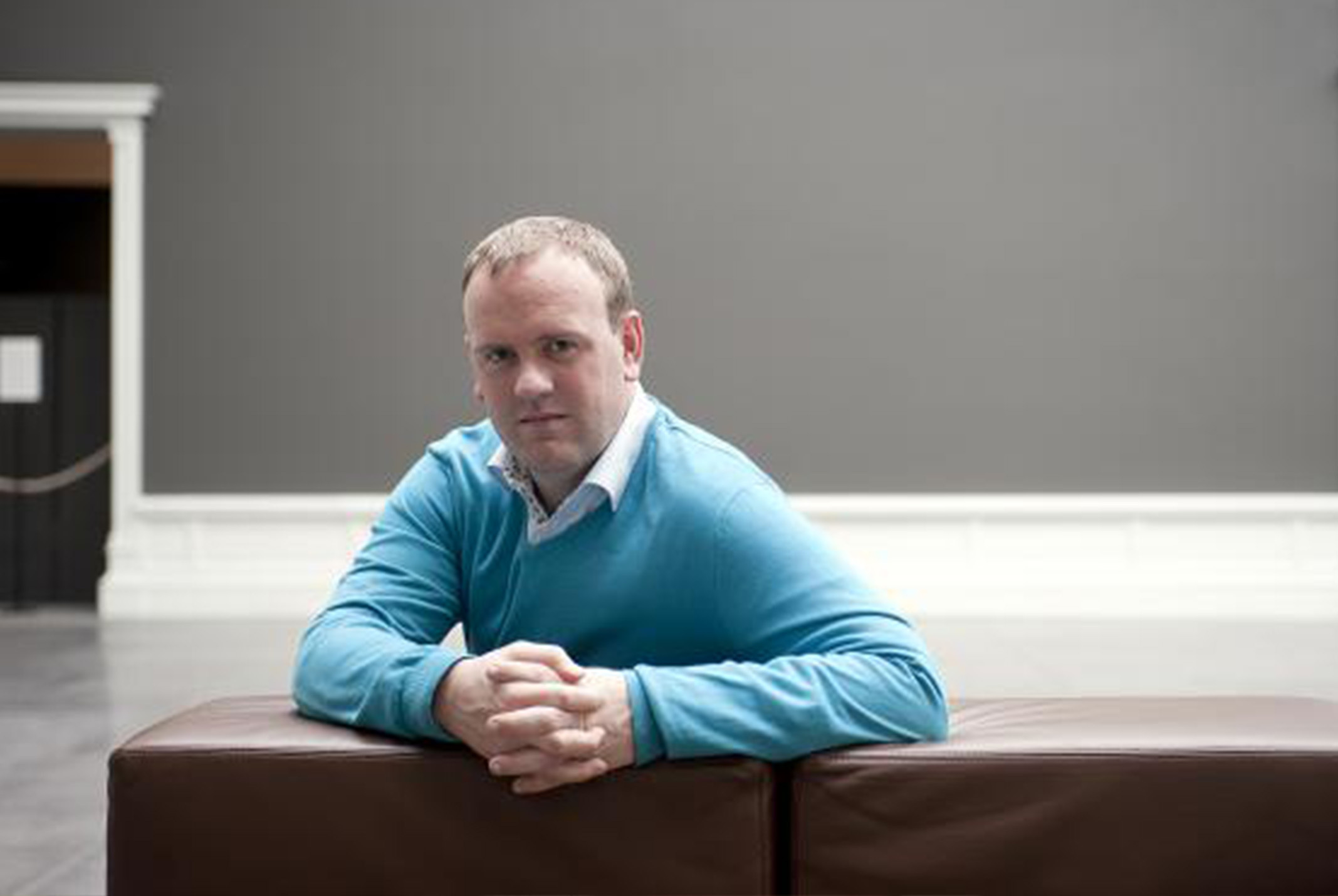 Steven van Belleghem in blauwe trui zittend op de bank