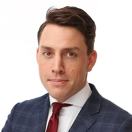 Rogier Elshout poserend in pak bij witte achtergrond