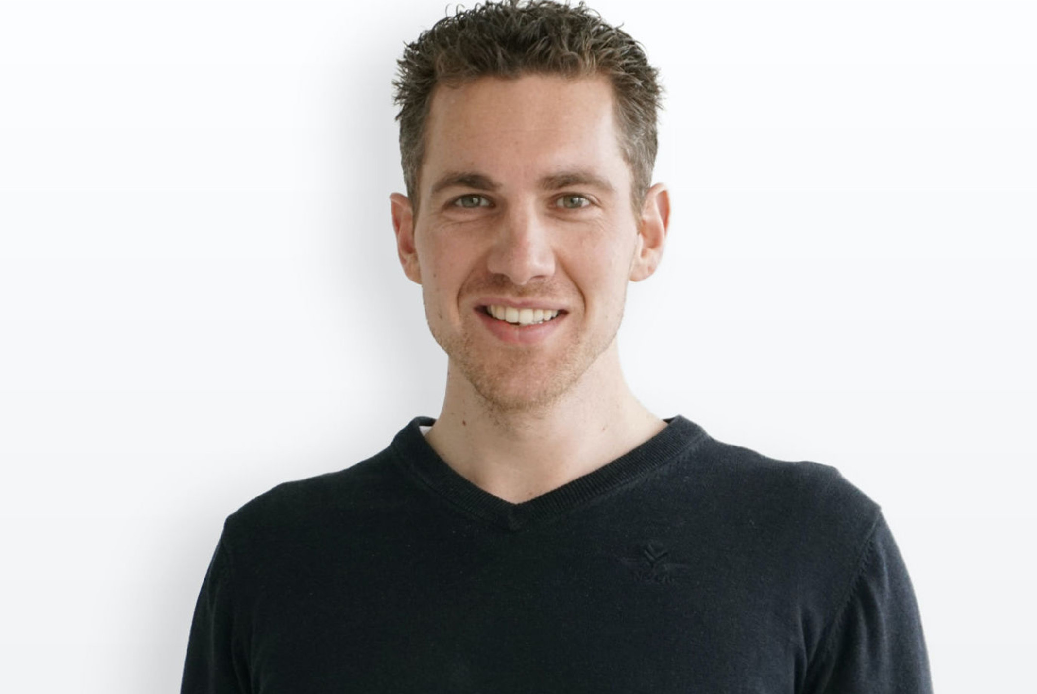 Bert Slagter glimlachend in zwart shirt bij witte achtergrond