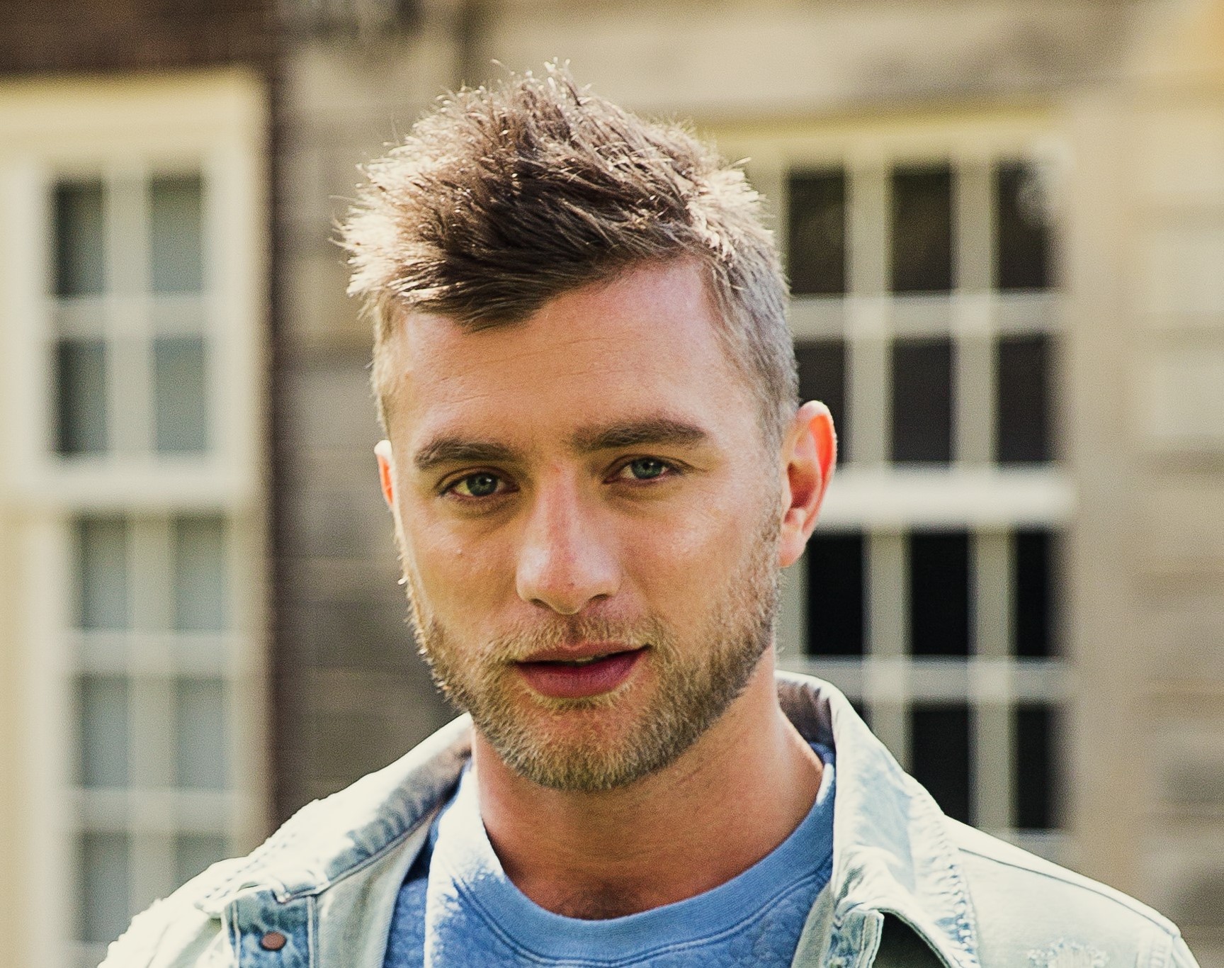 Jan Versteegh buiten poserend voor camera in spijkerjasje