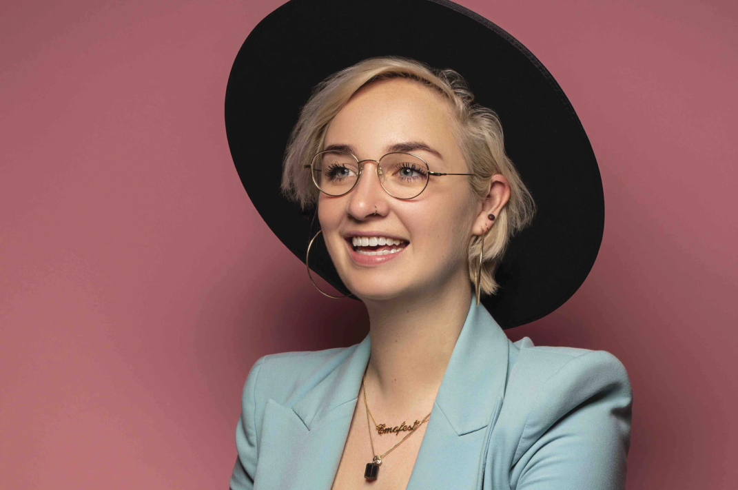 Danielle Jiskoot met hoed voor roze muur