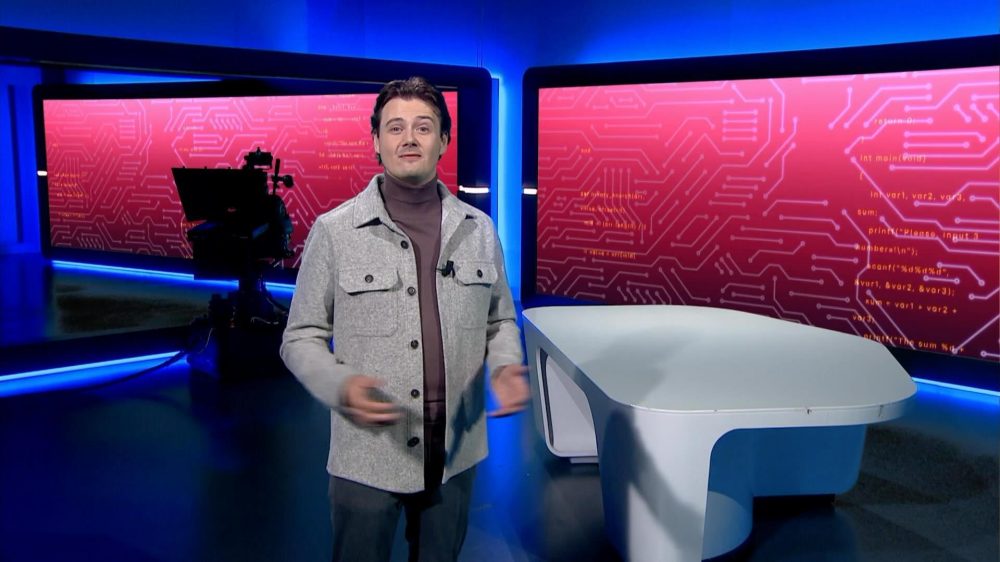 Remy Gieling in een cyberstudio in grijze vest