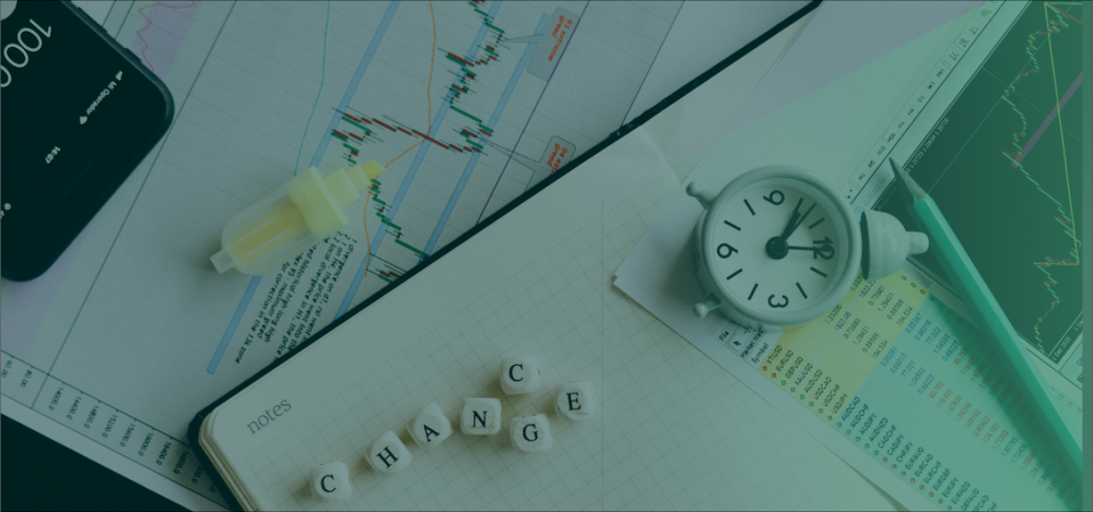 Timemanagement: Rommelige tafel met veel papieren, een potlood, een markeerstift en een bellenwekkertje.