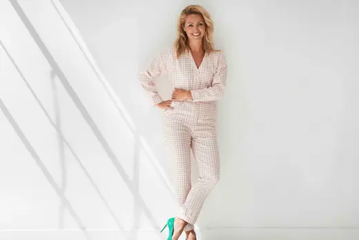 Debby Gerritsen in witte ruimte met geruit pak
