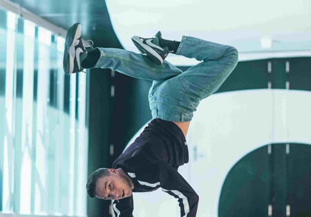 Redouan Ait Chitt poseert in handstand in gebouw