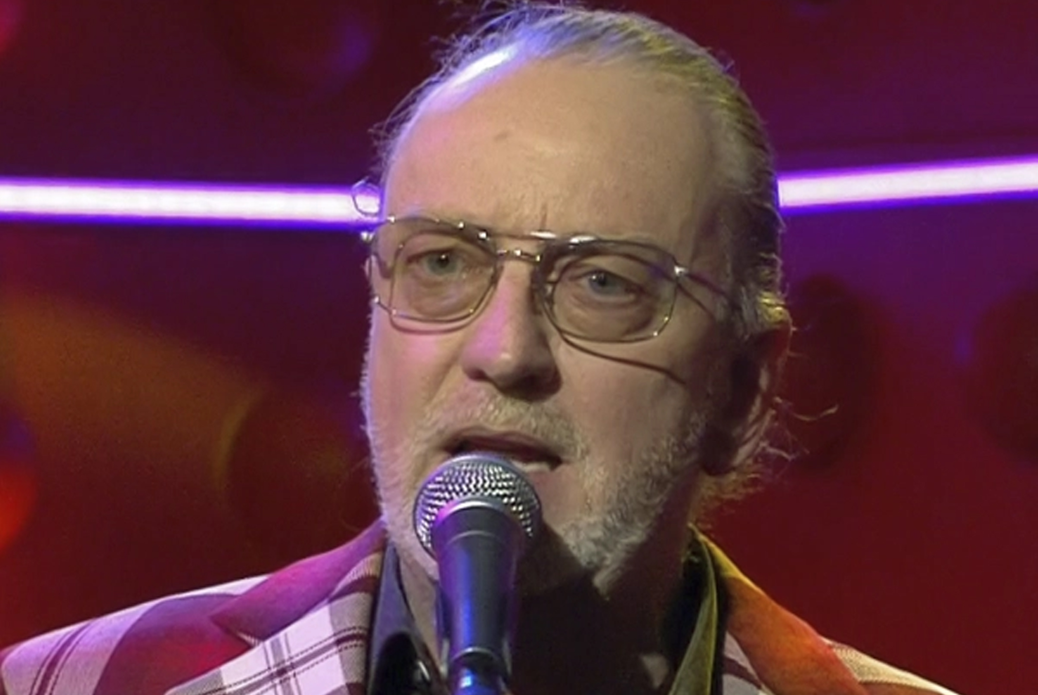 Ton Kas zingend achter microfoon