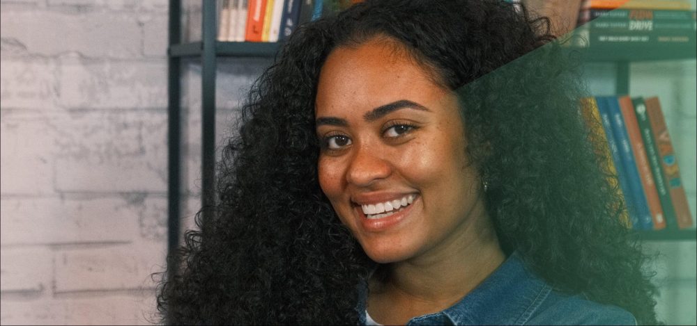 Ciana Mayam glimlachend in blauwe spijkerjas