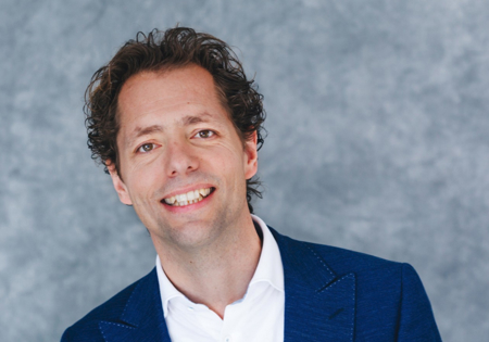 Joost van der Weijden lachend met grijze achtergrond