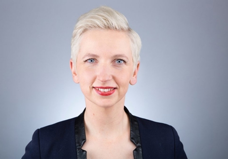 Marijke Roskam lachend in zwarte vest met witte achtergrond