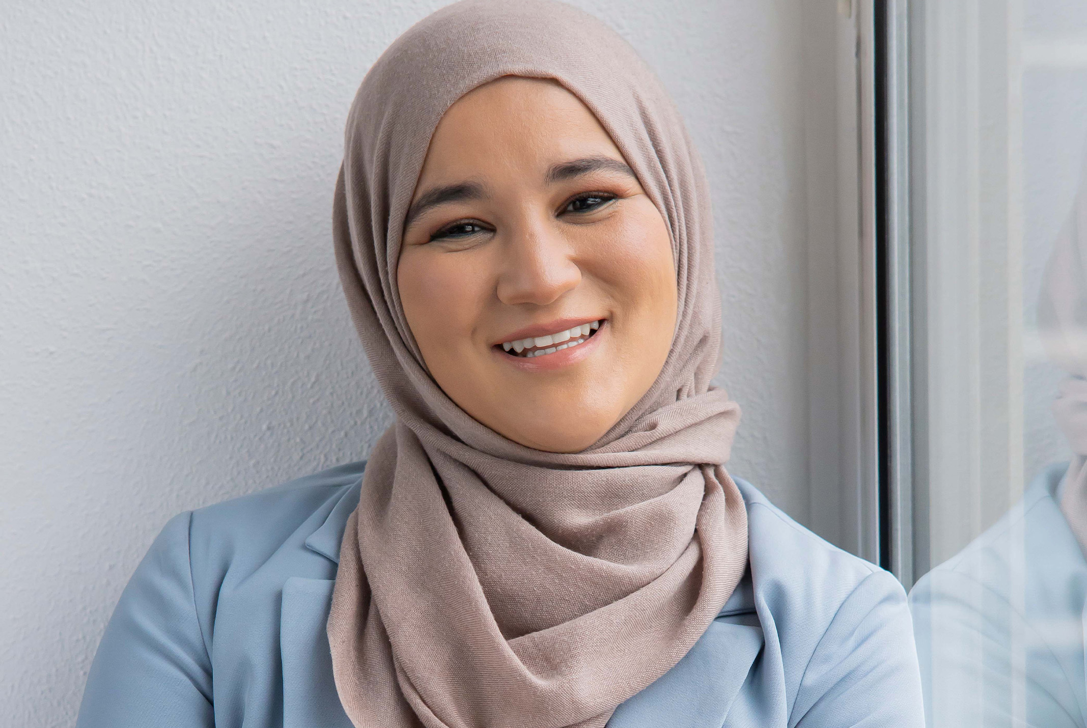 Houda Loukili lachend bij het raam