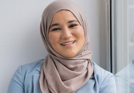 Houda Loukili lachend bij het raam