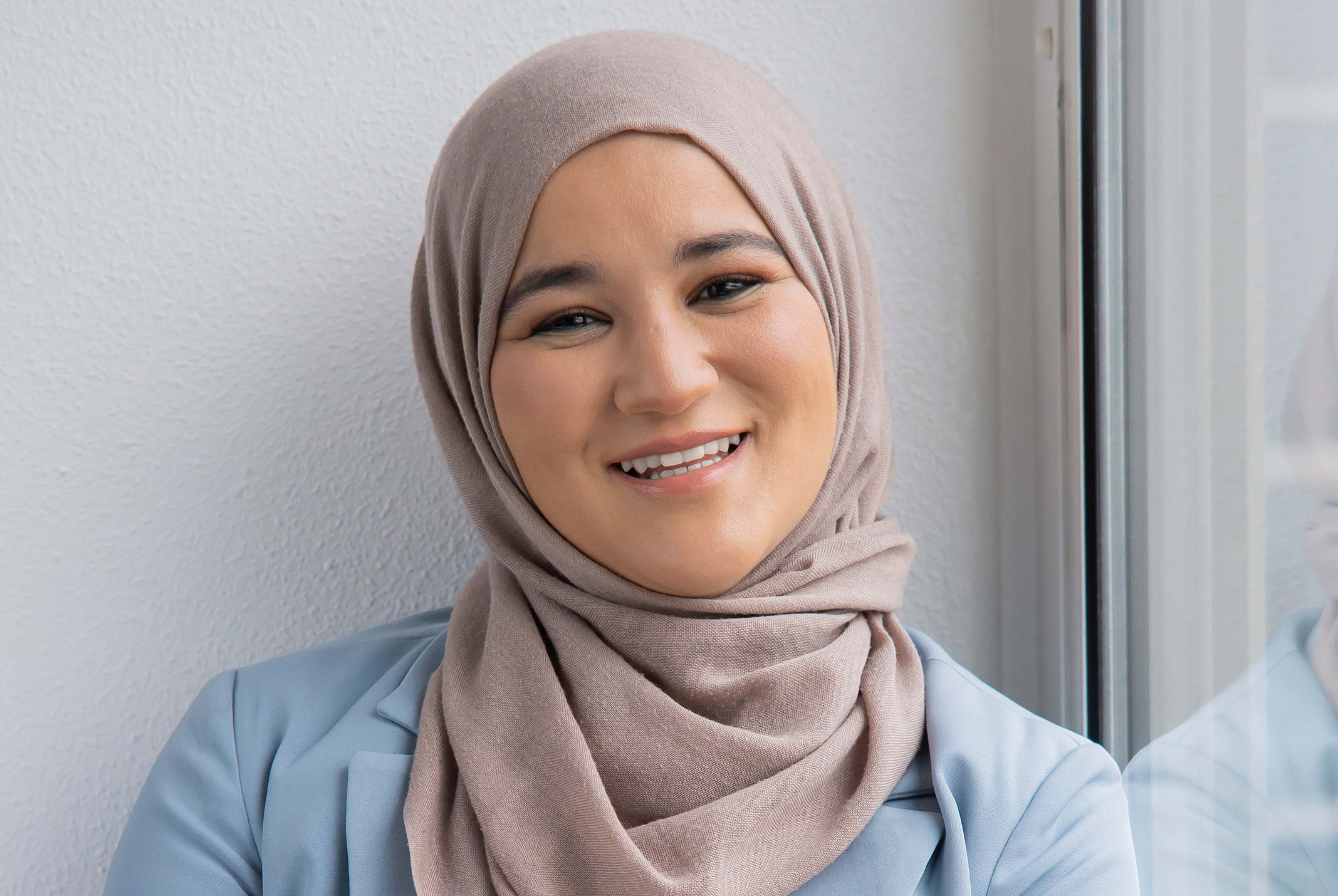 Houda Loukili lachend met bij het raam