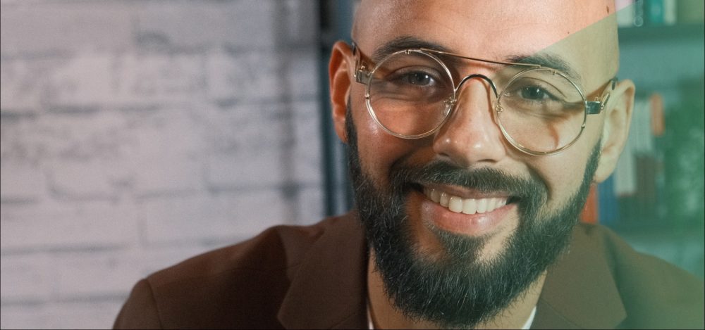 Karim Amghar glimlachend closeup in bruine blazer