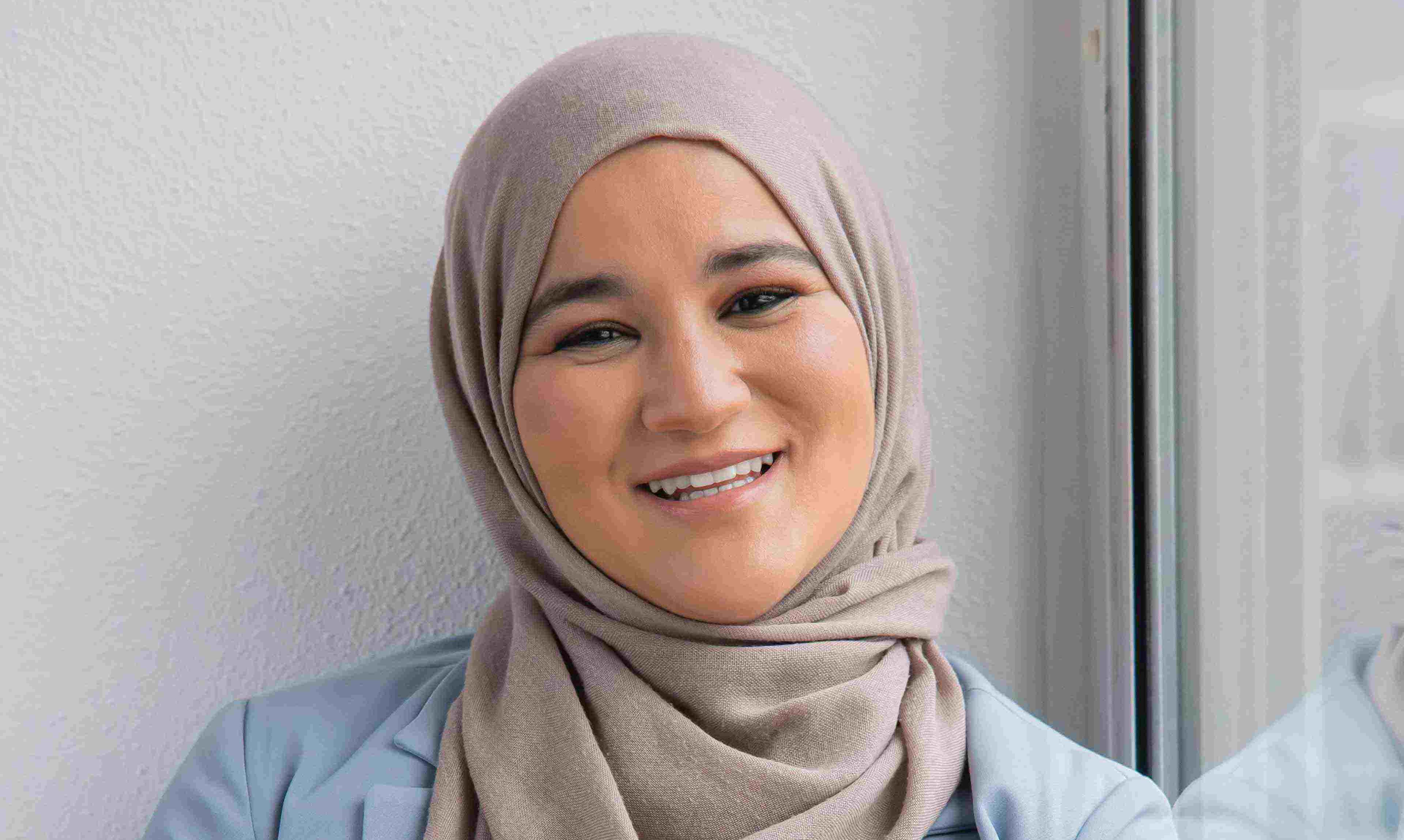 Houda Loukili in blauwe blouse en beige hijab