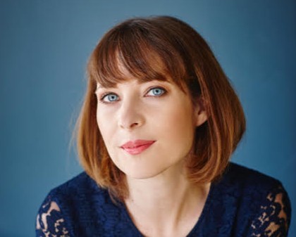 Vianne Bendermacher poserend in blauw shirt bij blouse achtergrond