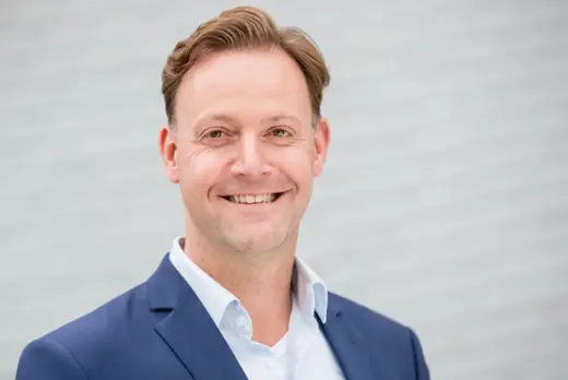 Robert van Overdijk in een blauw pak en wit overhemd
