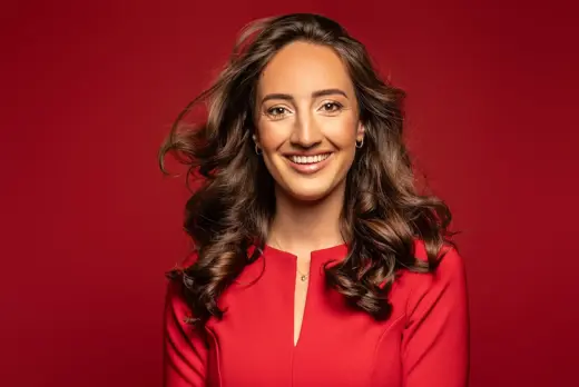 Laura Bas rode jurk en rode achtergrond