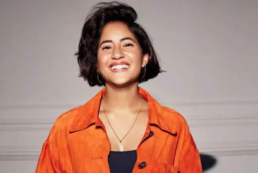 Frida Boeke in oranje overhemd voor witte achtergrond