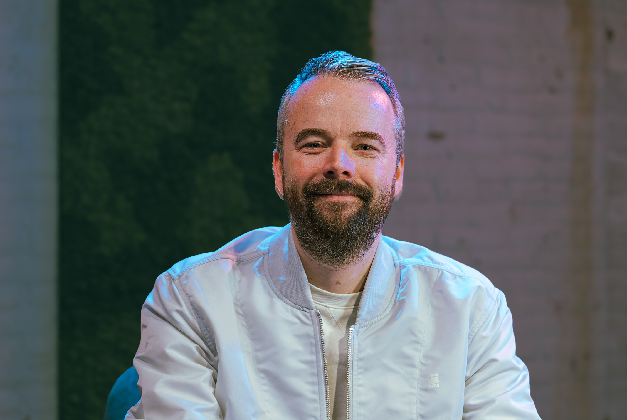 Jordi van de Bovenkamp in witte jas voor moswand