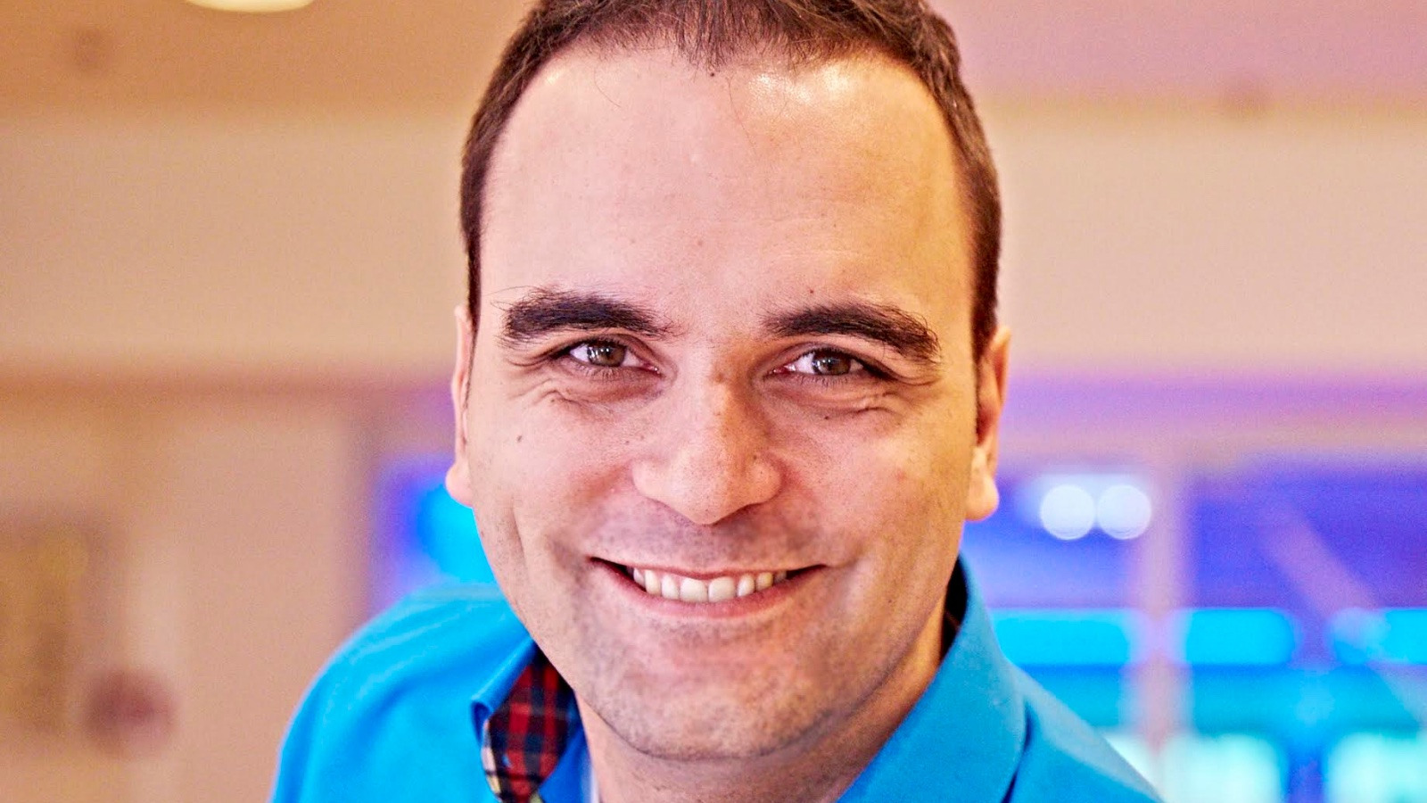 Jaap Bressers lachend in blauwe blouse binnen