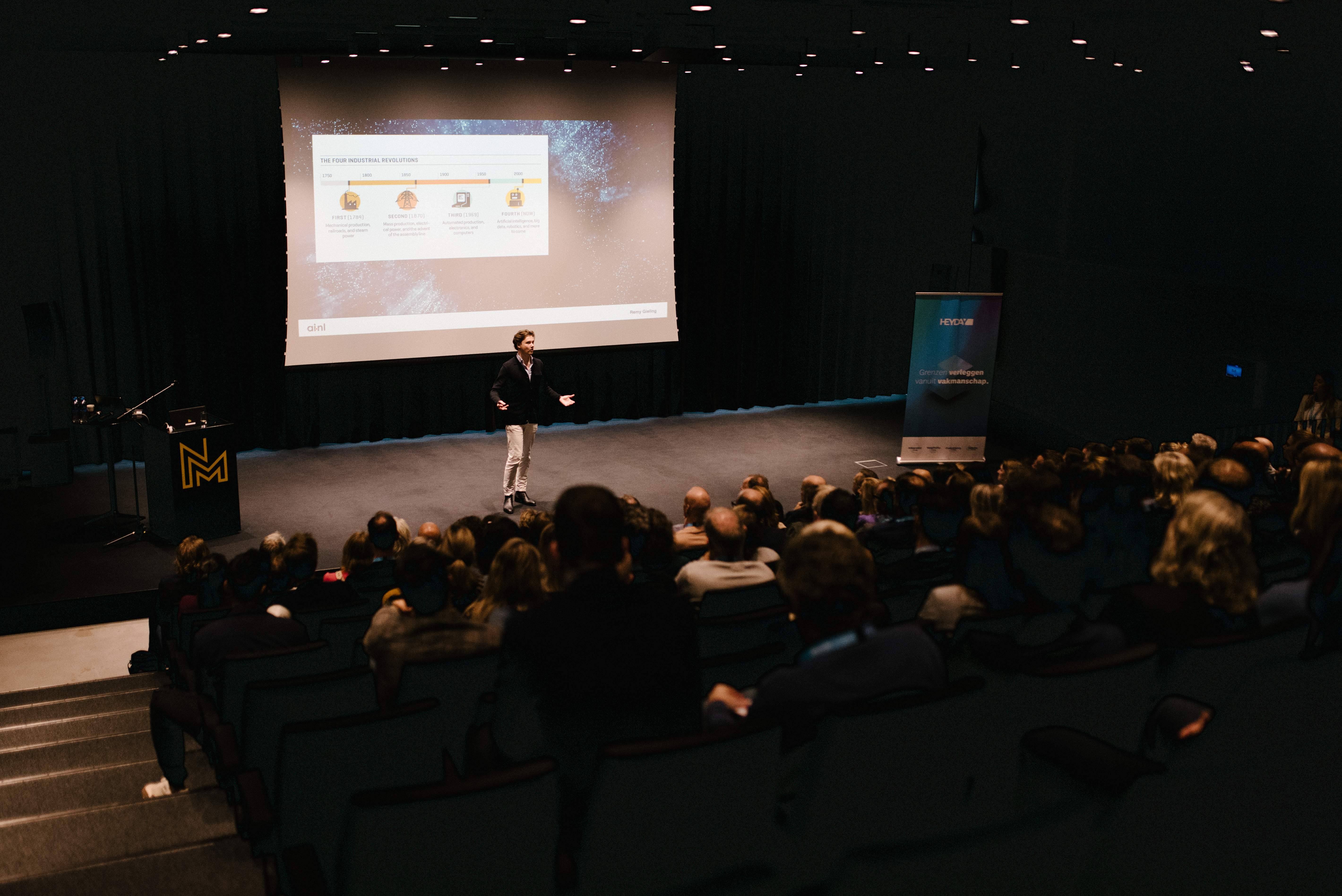 Remy Gieling in grote donkere zaal voor publiek