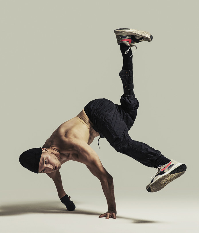 Redouan Ait-Chitt dansend met voeten in de lucht zonder shirt bij witte achtergrond