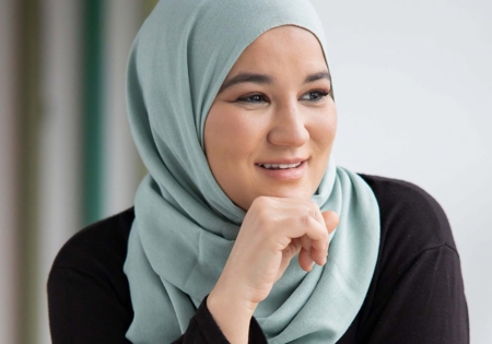 Houda Loukili lachend met hand bij kin