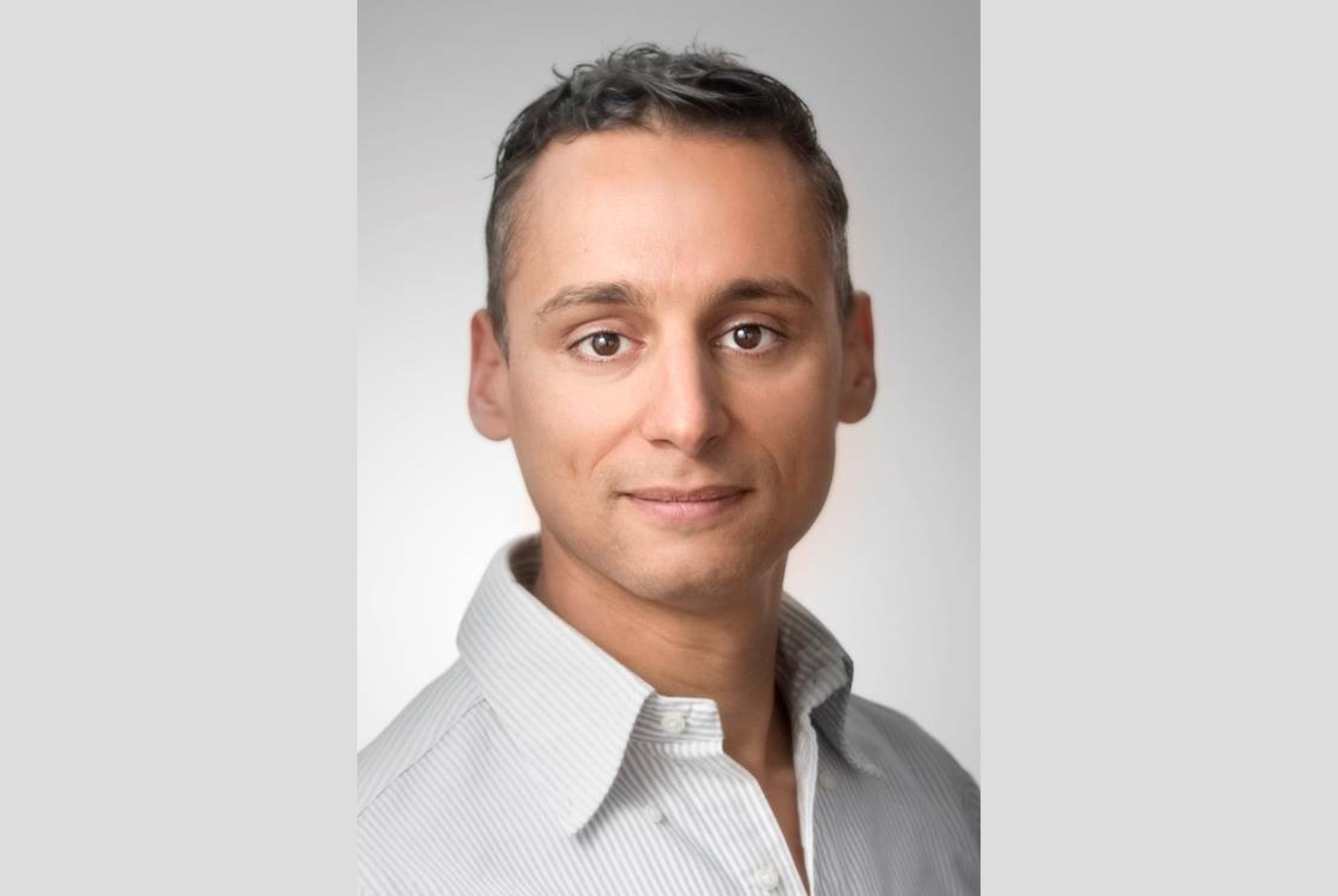 Farid Tabarki poserend in witte blouse met witte achtergrond