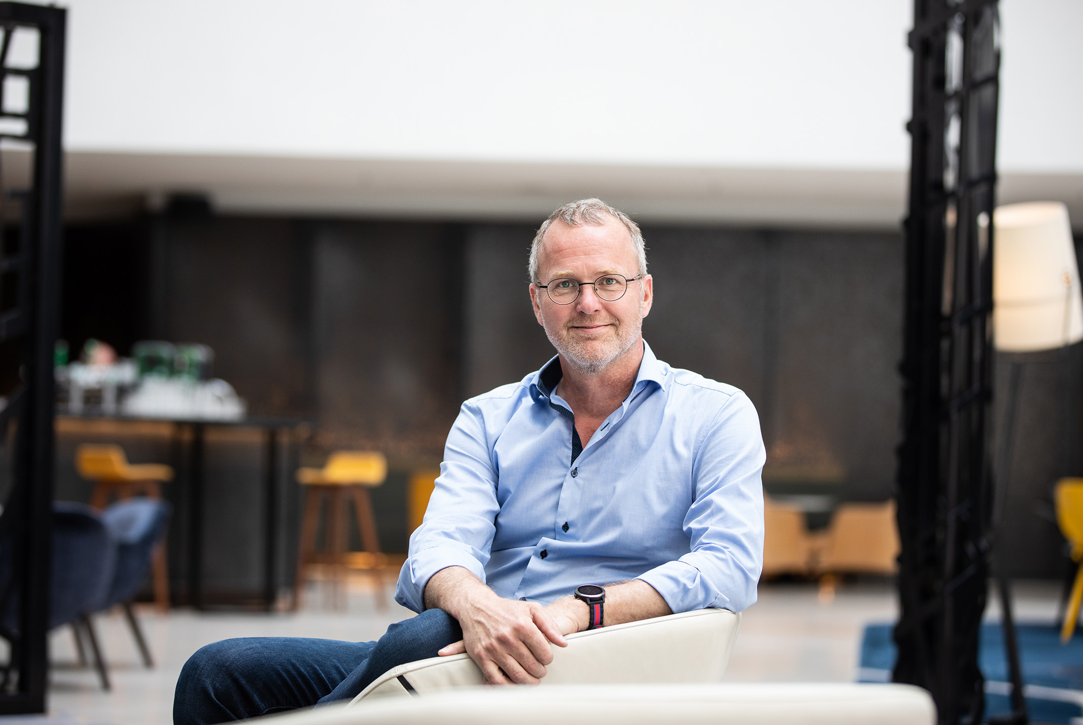 Patrick van Veen in een café met blauwe overhemd