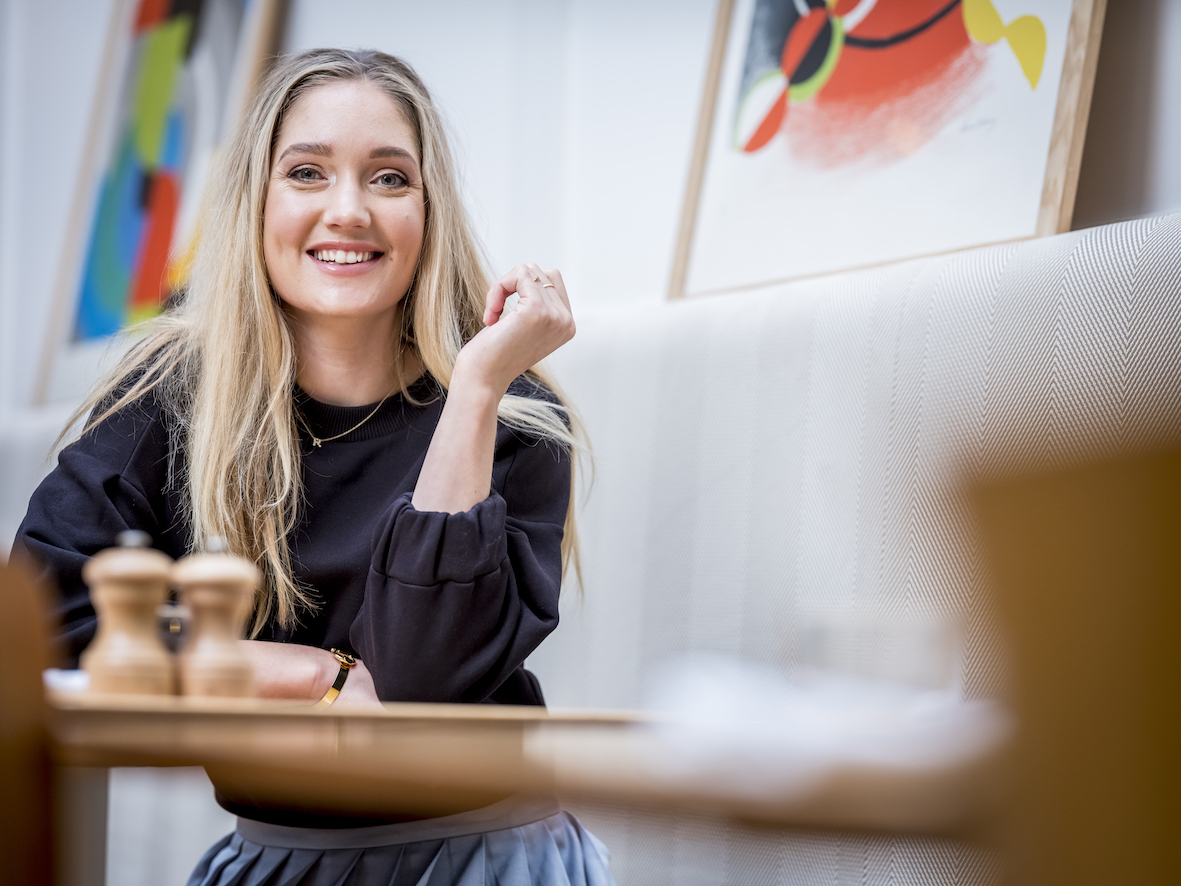 Rens Kroes glimlachend aan tafel in zwart shirt