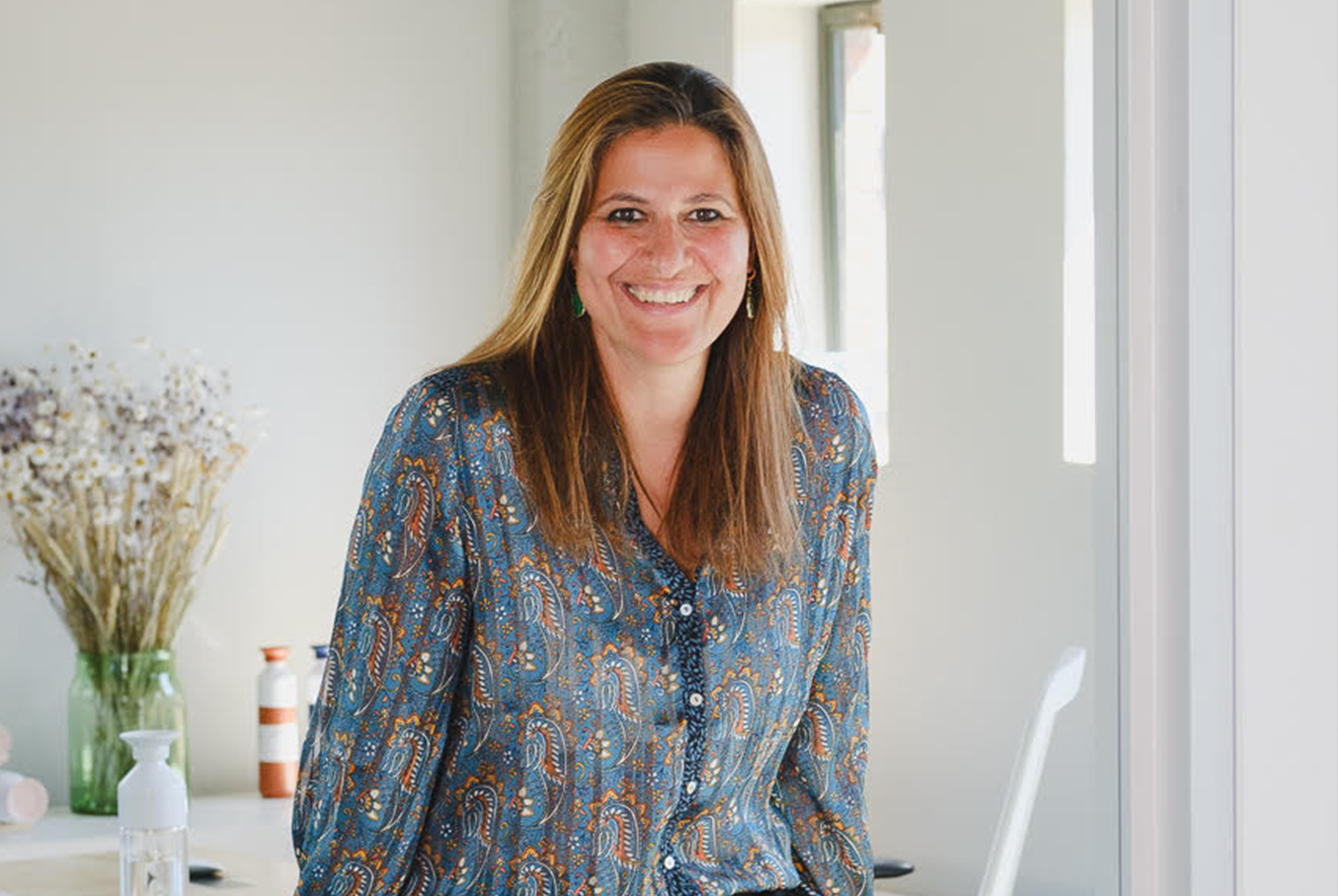 Lachende vrouw op een tafel met een bloem op de achtergrond