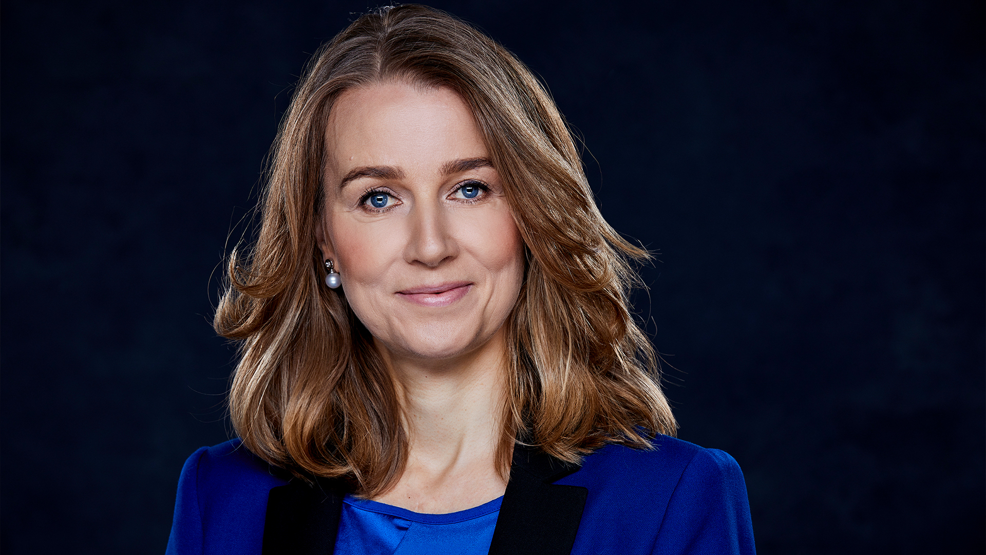 Vrouw in het blauw gekleed met een zwarte achtergrond