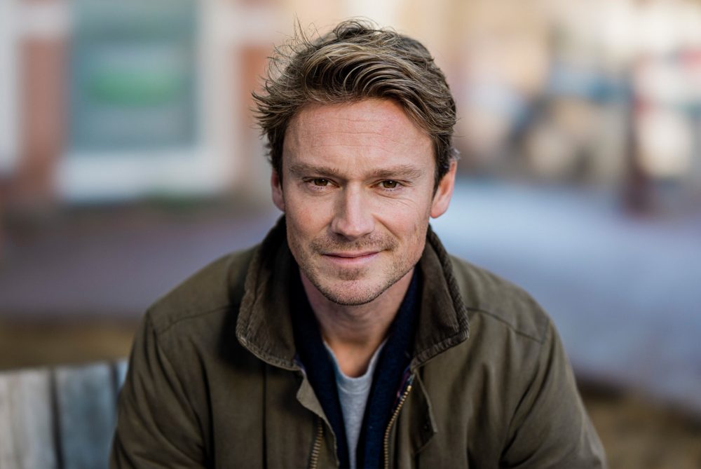 Sander Schimmelpenninck poserend buiten in groene jas