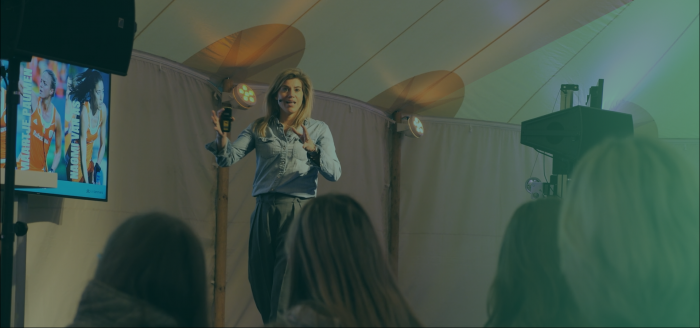 Kim Lammers bewegend met handen op het podium met groene gloed over zich